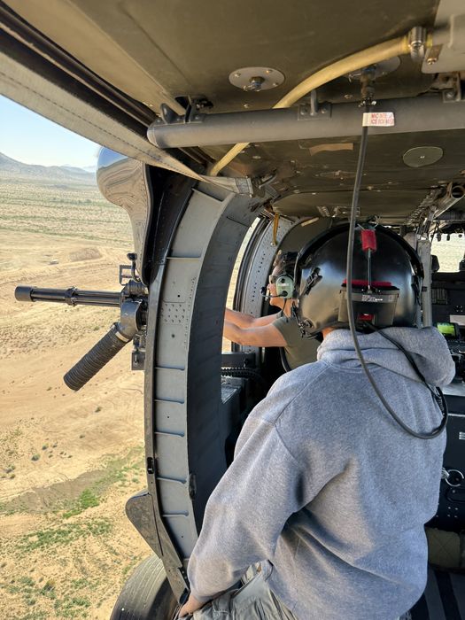 Crew looking out Black Hawk doorway in flight