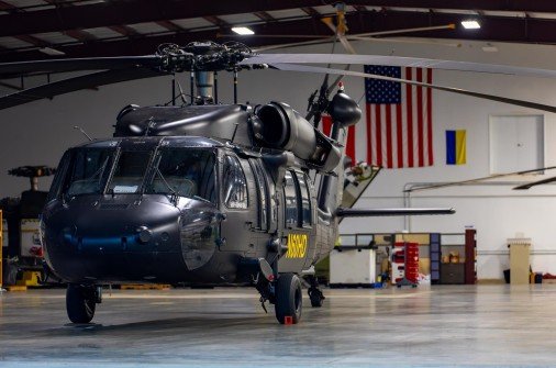 UH-60 Black Hawk in hangar — American flag backdrop